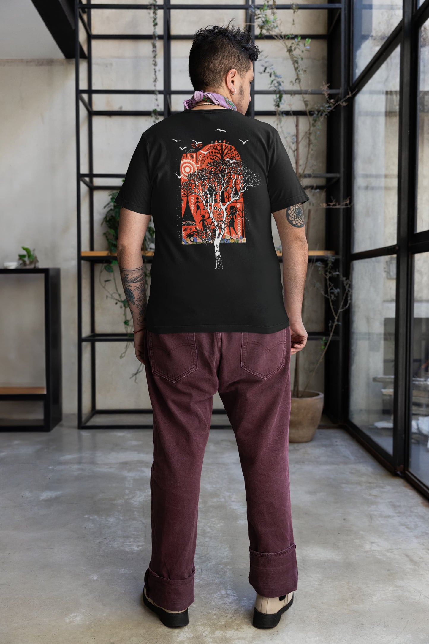 lifestyle photo, black Ancient Wonders Tee back view in studio space, bold red arch forest print